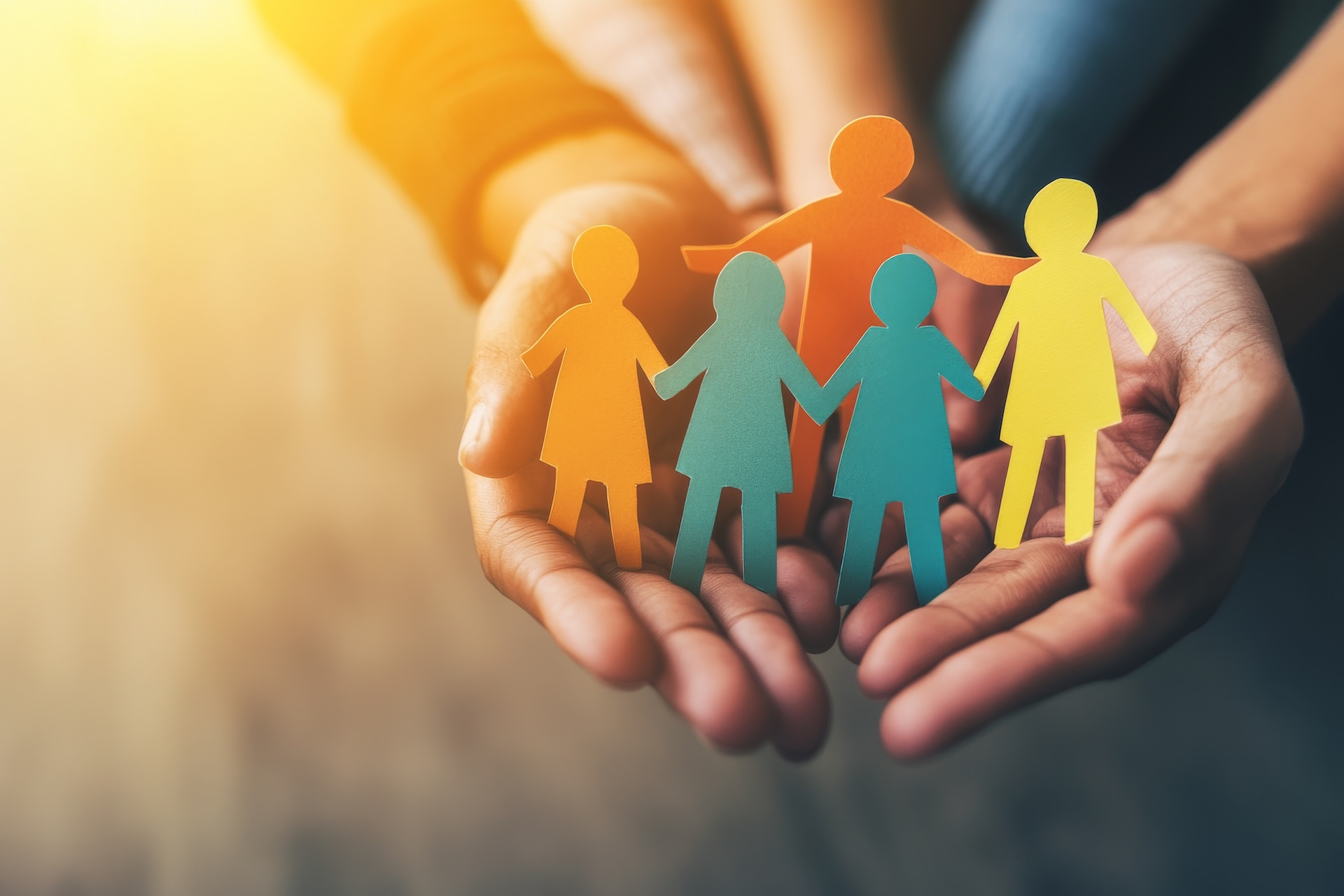 Children and adults holding a paper cutout of a family, a home, an adoption foster care program, a homeless charity, a household budget during inflation