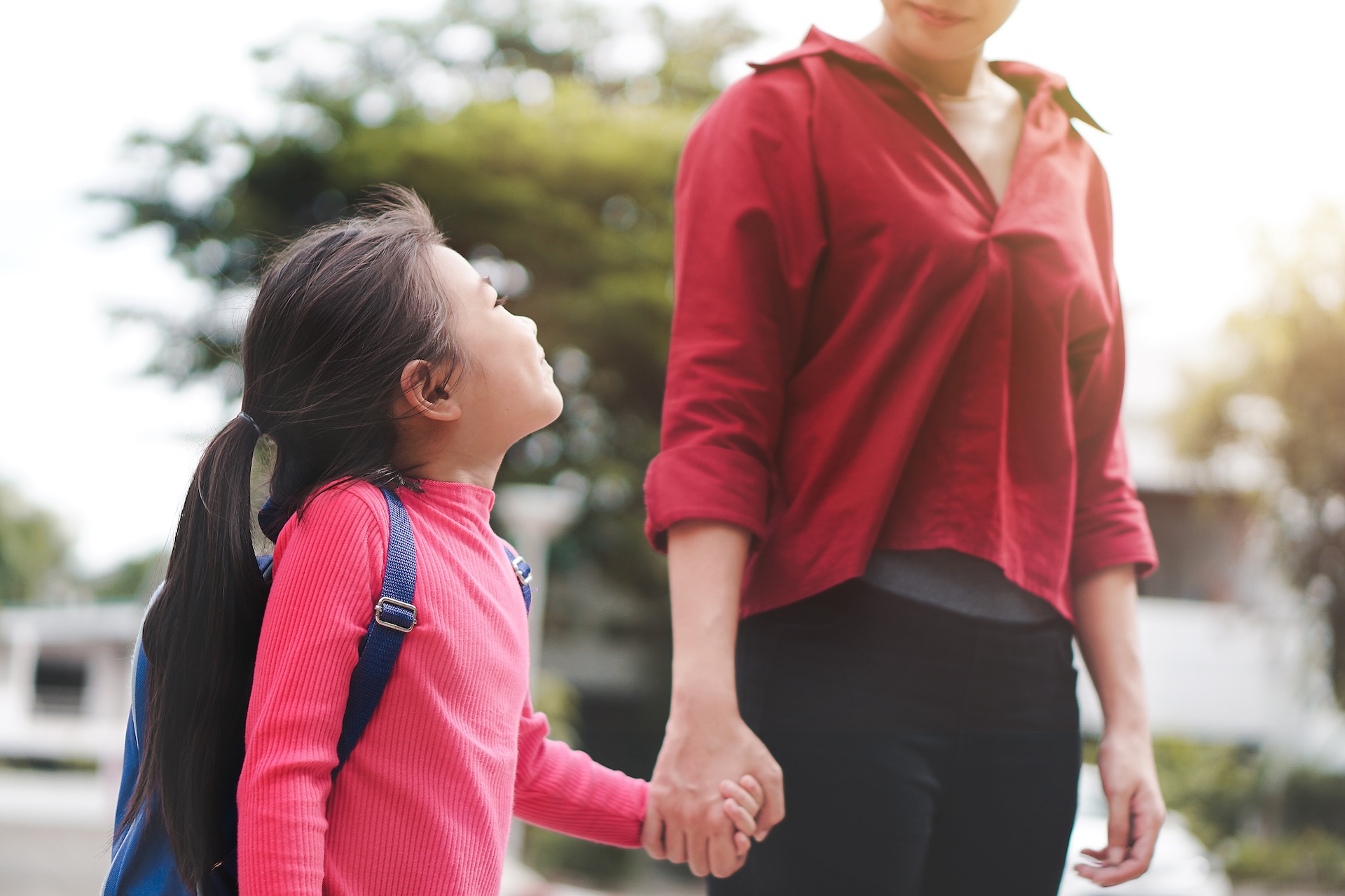 Back to school concept, Mother or parent holding hand daughter or pupil with backpack to school, Selective focus.