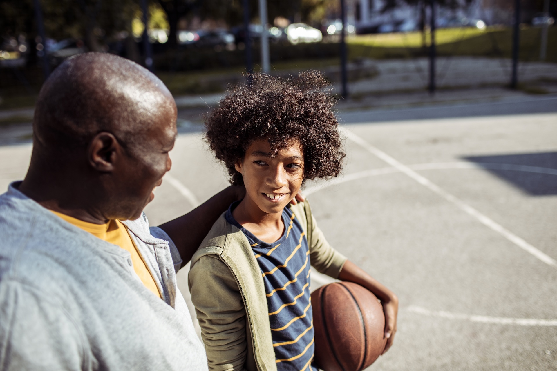 Close up of a grandfather playing basketball with his grandson